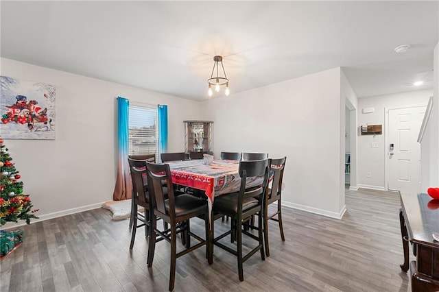 dining room with wood-type flooring and a notable chandelier