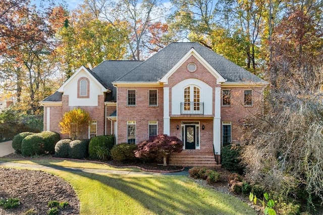 view of front of home featuring a balcony and a front lawn