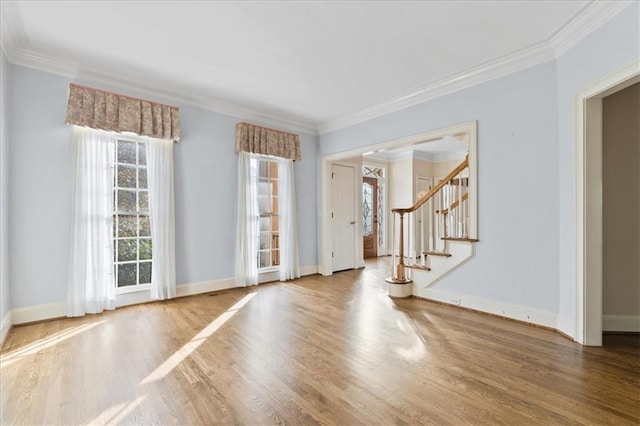 interior space featuring hardwood / wood-style floors, a wealth of natural light, and ornamental molding