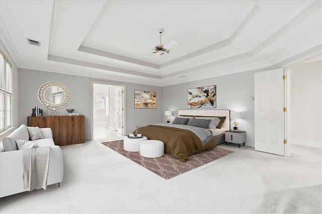 bedroom with ornamental molding, carpet floors, a raised ceiling, ceiling fan, and connected bathroom