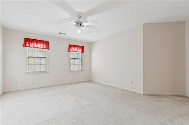 empty room featuring ceiling fan and light colored carpet