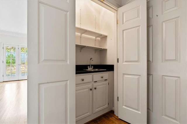 bar featuring french doors, white cabinetry, sink, and dark hardwood / wood-style floors