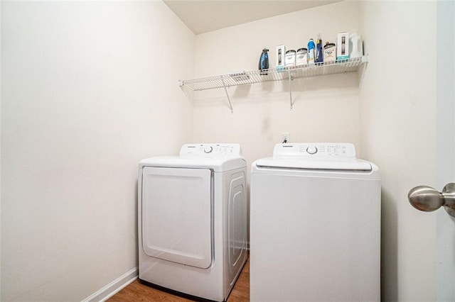 washroom with dark wood-type flooring and washer and clothes dryer