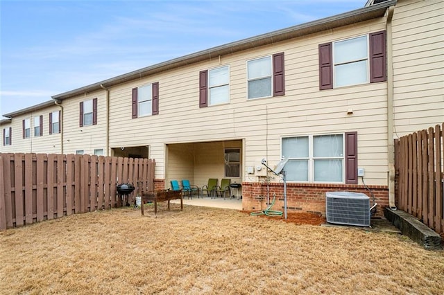 back of property featuring a lawn, central AC unit, and a patio area