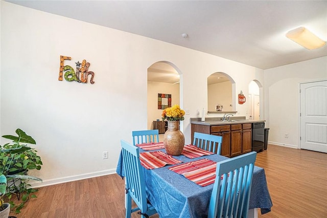 dining room with sink and light hardwood / wood-style flooring