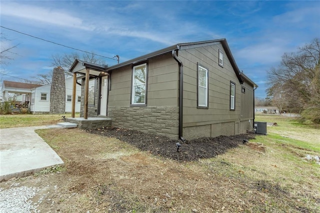 view of side of home featuring a yard and cooling unit