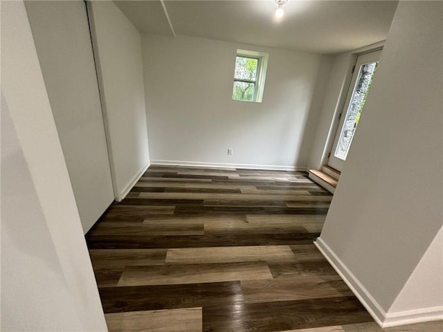 spare room featuring baseboards and wood finished floors