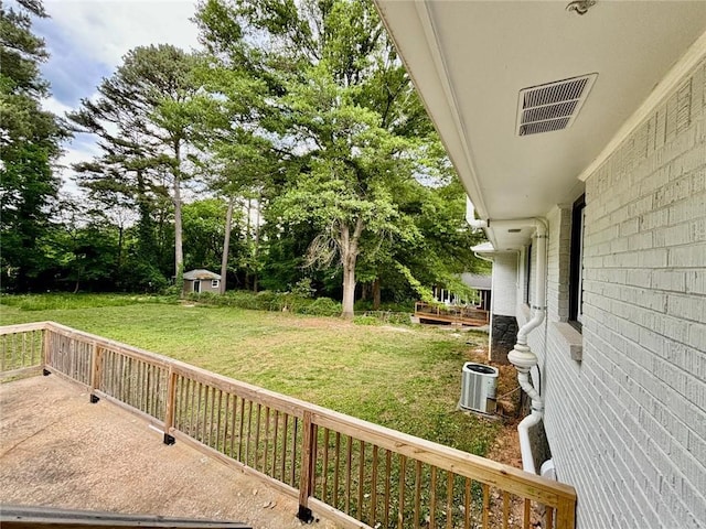 view of yard with an outbuilding, visible vents, central AC unit, and a storage unit