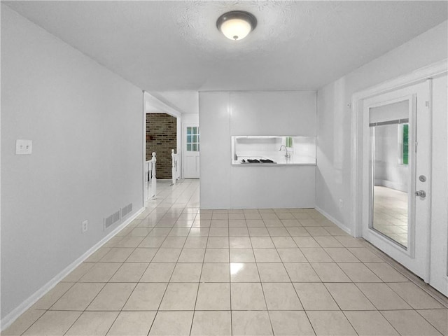 6389 Cumberland Dr, Rex, GA 30273 - spare room featuring light tile patterned floors, a textured ceiling, and baseboards