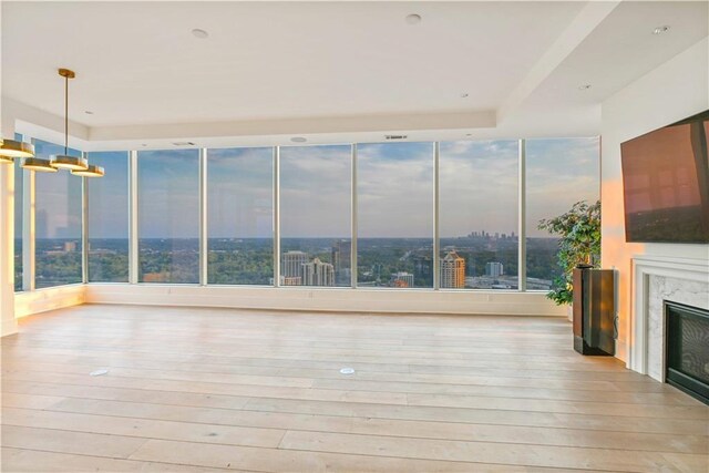 3630 Peachtree Rd NE Unit 3302, Atlanta, GA 30326 - unfurnished living room with visible vents, a fireplace, wood-type flooring, a city view, and a tray ceiling