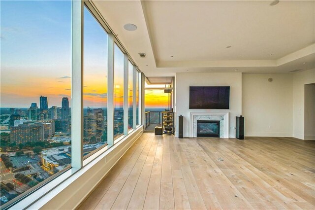 3630 Peachtree Rd NE Unit 3302, Atlanta, GA 30326 - unfurnished living room with a fireplace, a tray ceiling, hardwood / wood-style floors, and visible vents