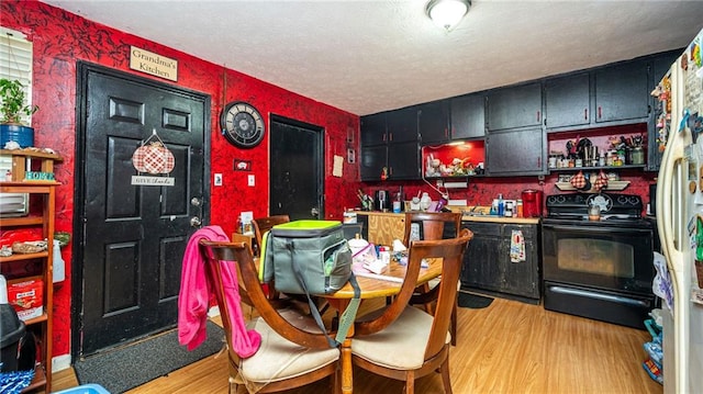 kitchen with white refrigerator, a textured ceiling, electric range, and light hardwood / wood-style floors