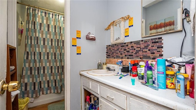 bathroom featuring hardwood / wood-style floors, shower / bath combination with curtain, decorative backsplash, and vanity