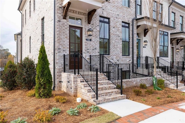 view of exterior entry featuring brick siding