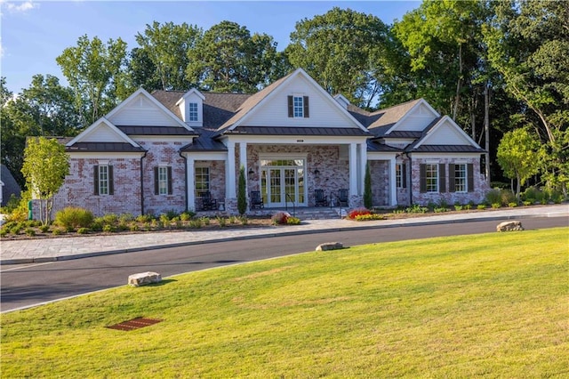 view of front of property with a standing seam roof, a front lawn, and metal roof