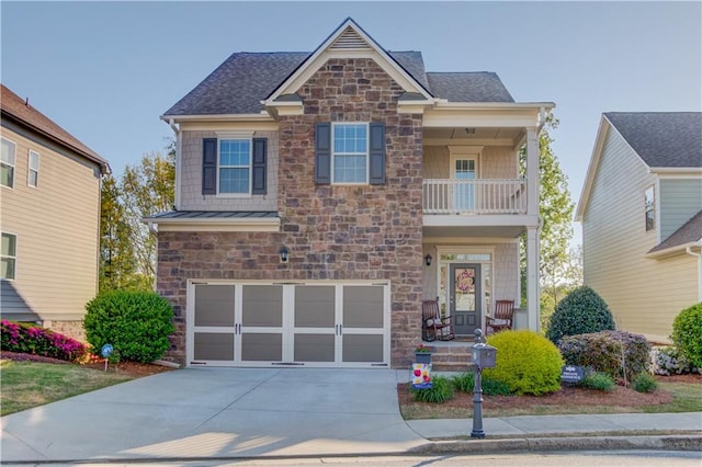 craftsman-style house featuring a balcony, driveway, stone siding, an attached garage, and a standing seam roof