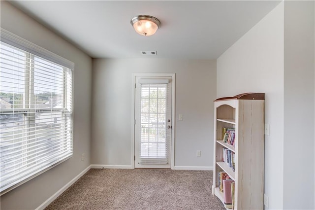 carpeted empty room featuring visible vents and baseboards
