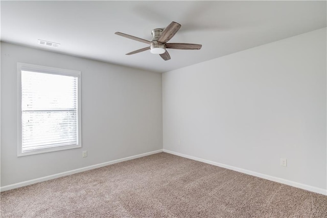 carpeted empty room featuring ceiling fan, baseboards, and visible vents