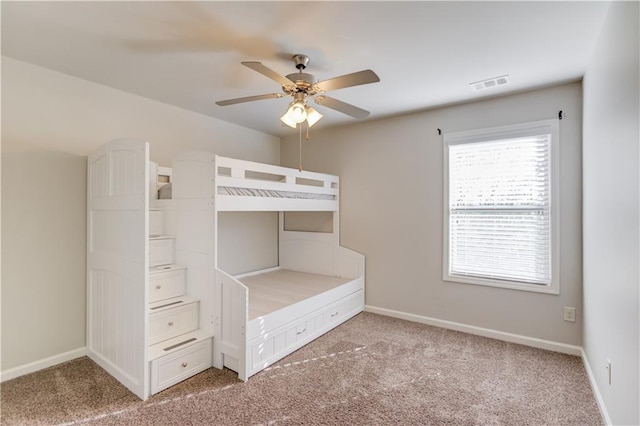 unfurnished bedroom with visible vents, baseboards, ceiling fan, and light carpet