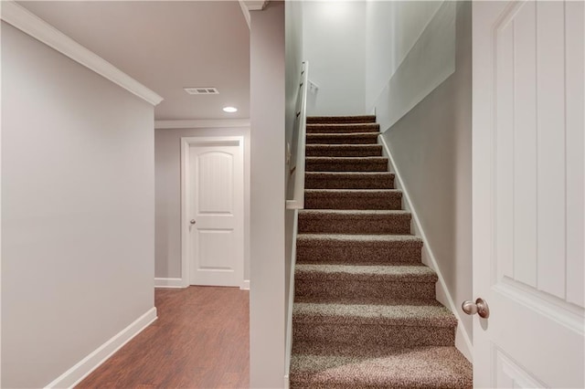 staircase featuring visible vents, baseboards, ornamental molding, recessed lighting, and wood finished floors