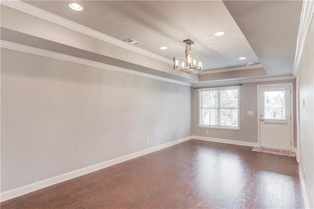 empty room featuring dark wood-type flooring, visible vents, an inviting chandelier, and crown molding