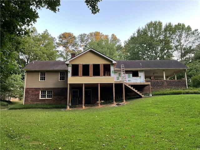 rear view of house with a wooden deck and a lawn