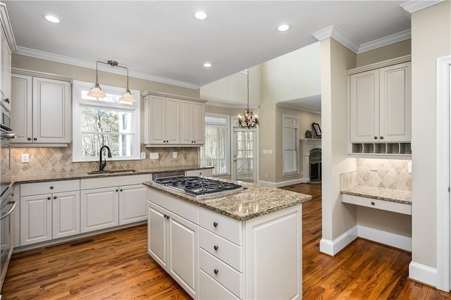 kitchen featuring white cabinetry, sink, and hanging light fixtures