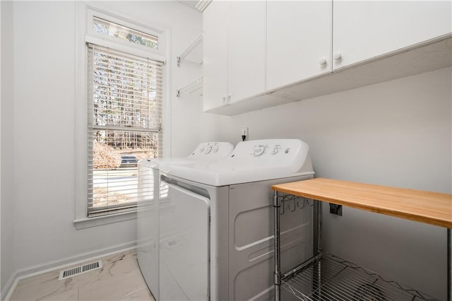 laundry area featuring plenty of natural light, cabinets, and separate washer and dryer