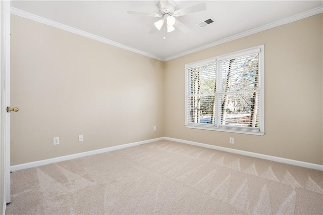 spare room with ceiling fan, light colored carpet, and crown molding