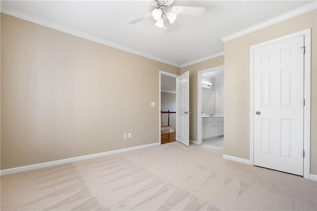 unfurnished bedroom featuring light colored carpet, ensuite bath, ceiling fan, and crown molding