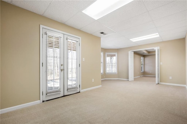 carpeted empty room with french doors and a paneled ceiling