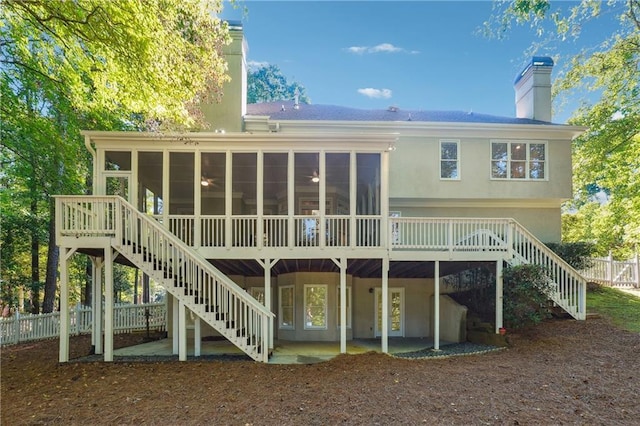 back of house with a sunroom, a patio area, and a wooden deck