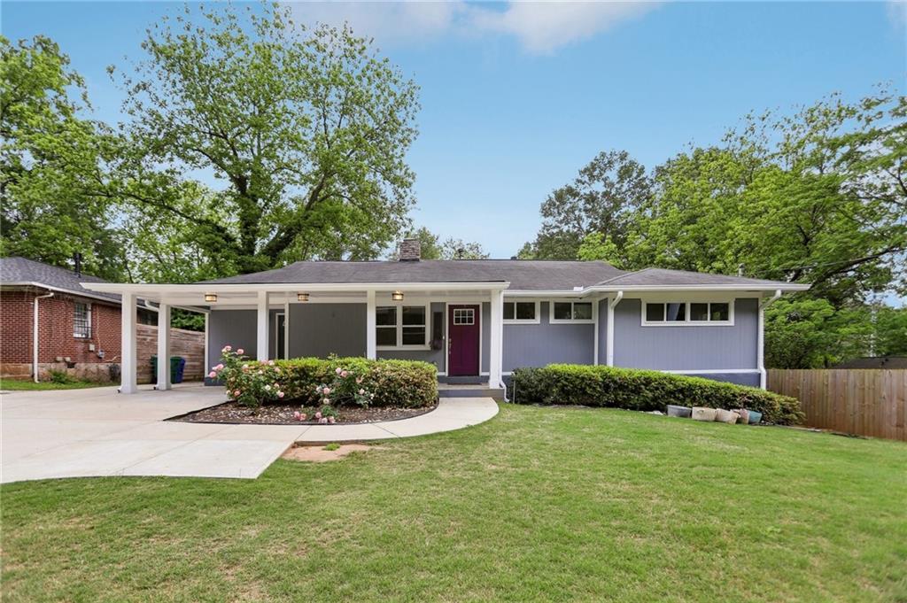1281 Snapfinger Rd, Decatur, GA 30032 - view of front facade featuring a chimney, fence, a front lawn, concrete driveway, and an attached carport