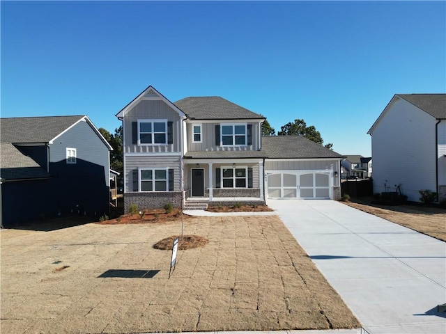 view of front of home featuring board and batten siding, brick siding, driveway, and a garage