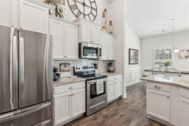 kitchen with visible vents, decorative light fixtures, appliances with stainless steel finishes, dark wood-style floors, and white cabinets