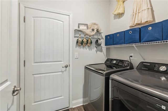 laundry room with laundry area, dark wood-style floors, separate washer and dryer, and baseboards