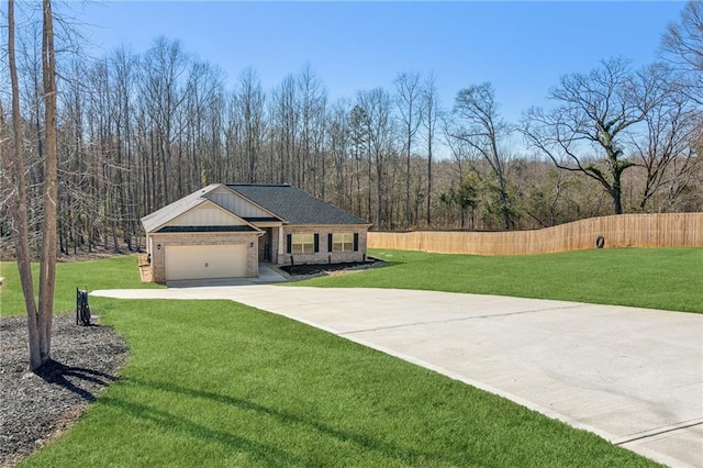 view of side of home with brick siding, fence, concrete driveway, a garage, and a yard