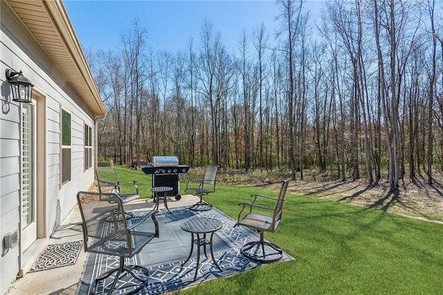 view of patio with a view of trees and area for grilling