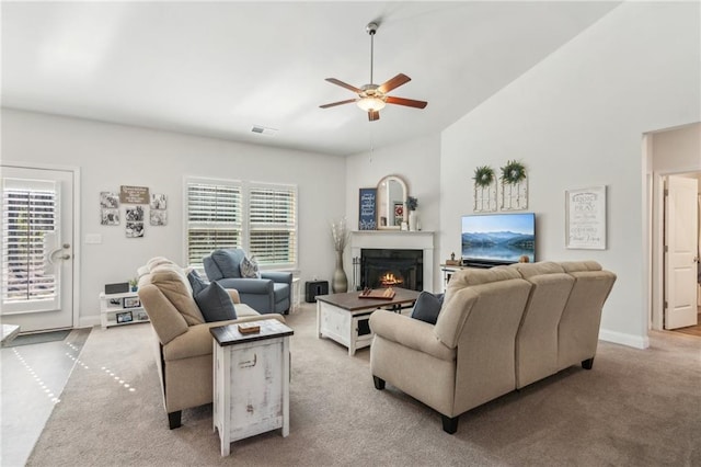 living room featuring visible vents, a lit fireplace, carpet flooring, baseboards, and vaulted ceiling