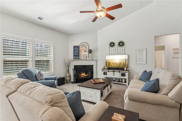 carpeted living area with a glass covered fireplace, a ceiling fan, and visible vents