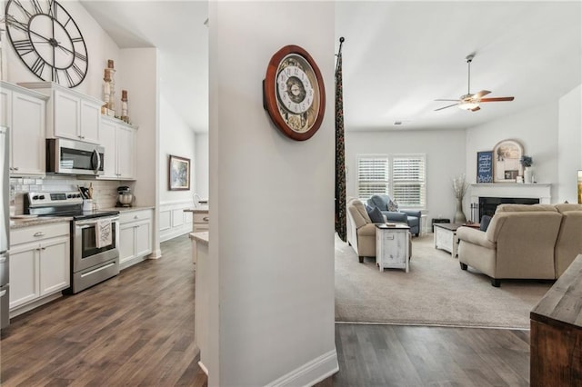 kitchen with a fireplace, open floor plan, backsplash, and stainless steel appliances