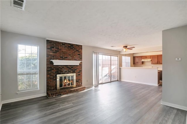 unfurnished living room with dark hardwood / wood-style flooring, ceiling fan, and a fireplace