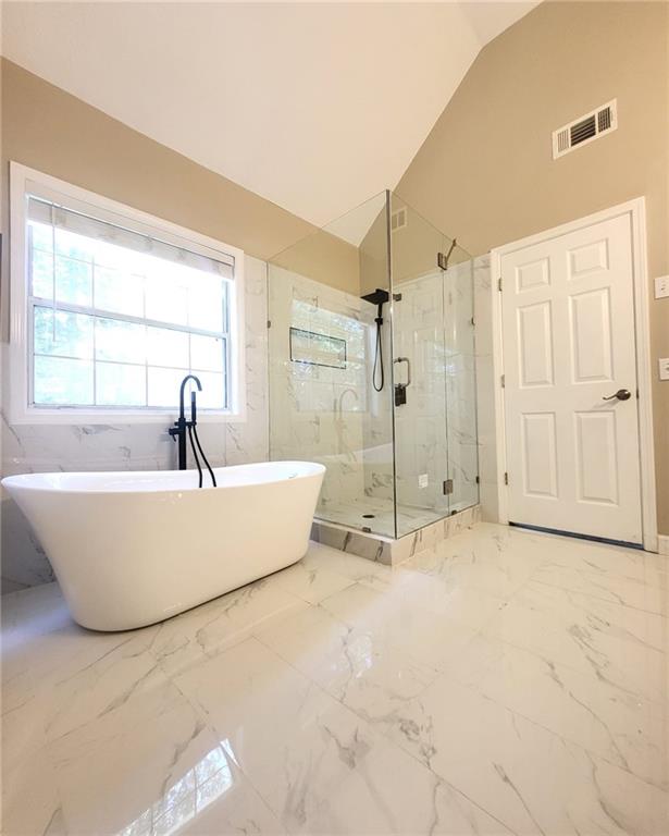 5705 Cannonero Dr, Alpharetta, GA 30005 - full bathroom featuring a marble finish shower, vaulted ceiling, and a freestanding bath