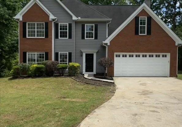 5705 Cannonero Dr, Alpharetta, GA 30005 - view of front of property with concrete driveway, a chimney, a front lawn, and a garage