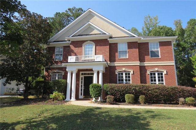 view of front of property featuring a front lawn and a balcony