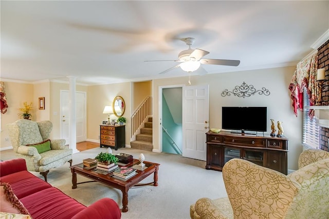 carpeted living room featuring crown molding, ceiling fan, and ornate columns