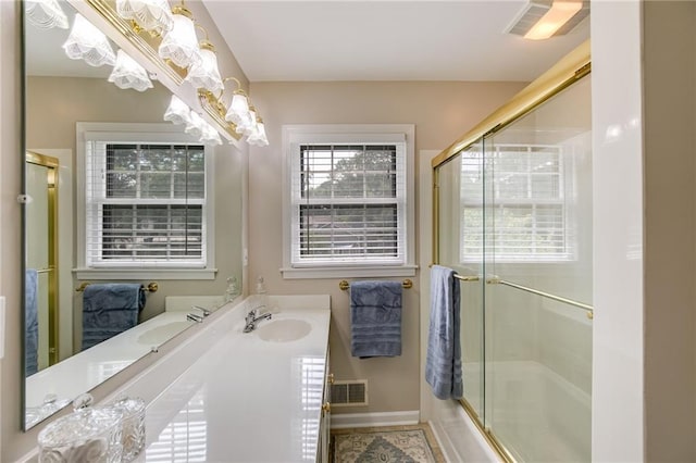 bathroom with vanity and shower / bath combination with glass door