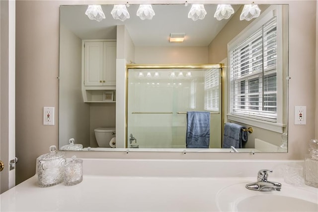 bathroom featuring walk in shower, sink, and toilet