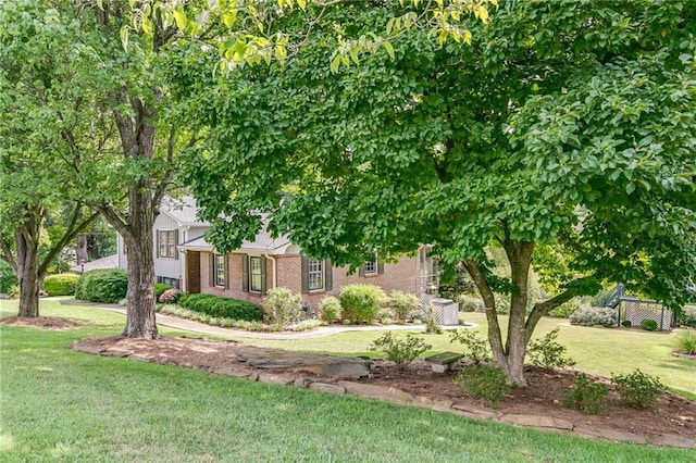 obstructed view of property with a front lawn