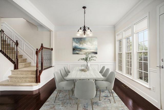 dining area featuring crown molding, dark wood-type flooring, and an inviting chandelier